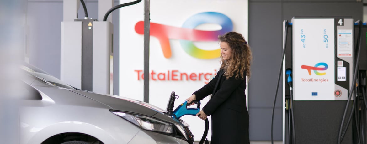 Woman charging her vehicle at the electric station