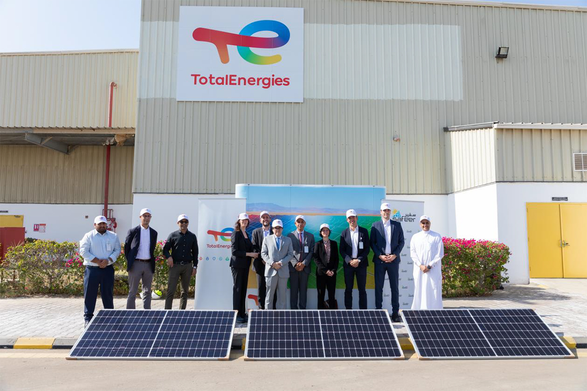 executives of TotalEnergies and Safeer standing in front of lubricants plant with solar panels