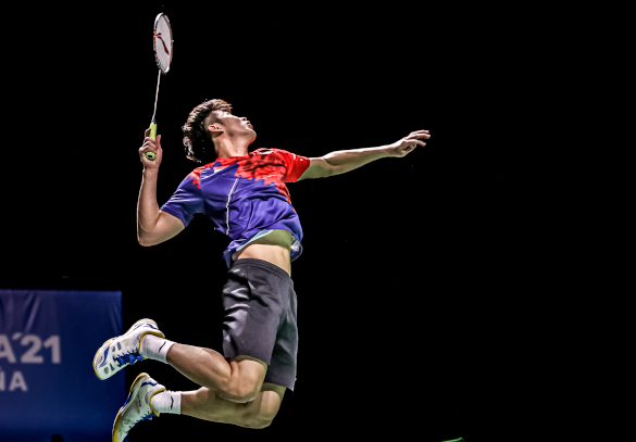 badminton player jumping to perform a smash