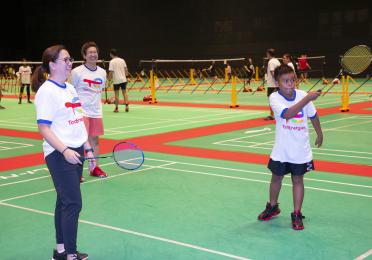 TotalEnergies employees playing badminton with youths from Beyond Social Services