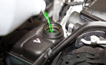 pouring antifreeze to car