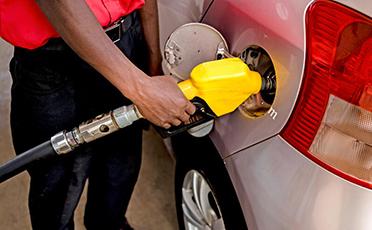 Gas station attendant pumping fuel in a car