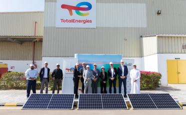 executives of TotalEnergies and Safeer standing in front of lubricants plant with solar panels