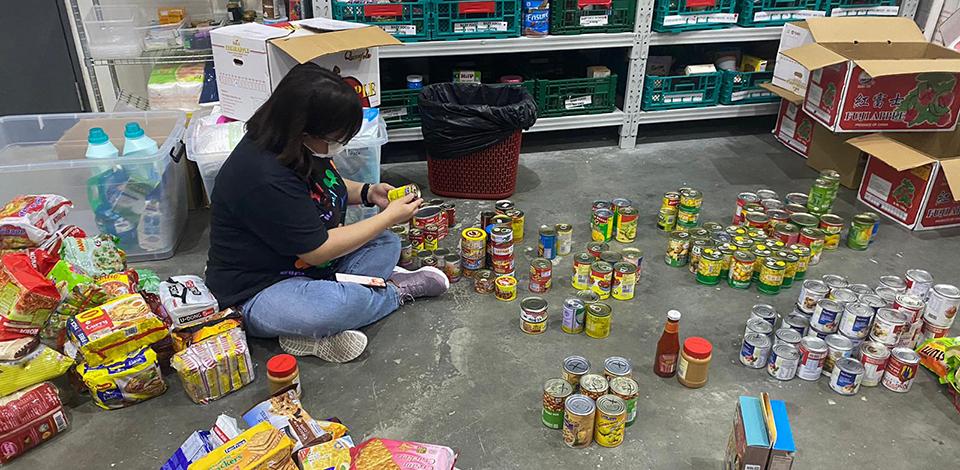 an employee sorting out canned food at FoodBank warehouse
