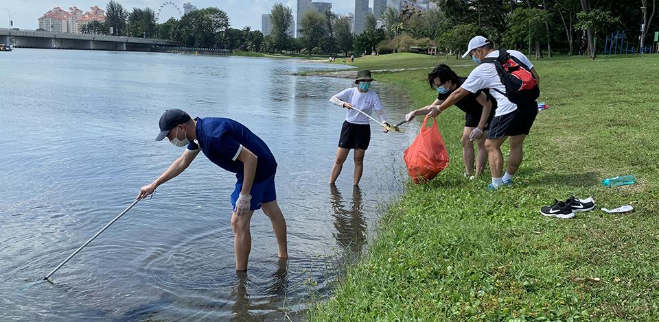 employees picking up litter along Marina Reservoir